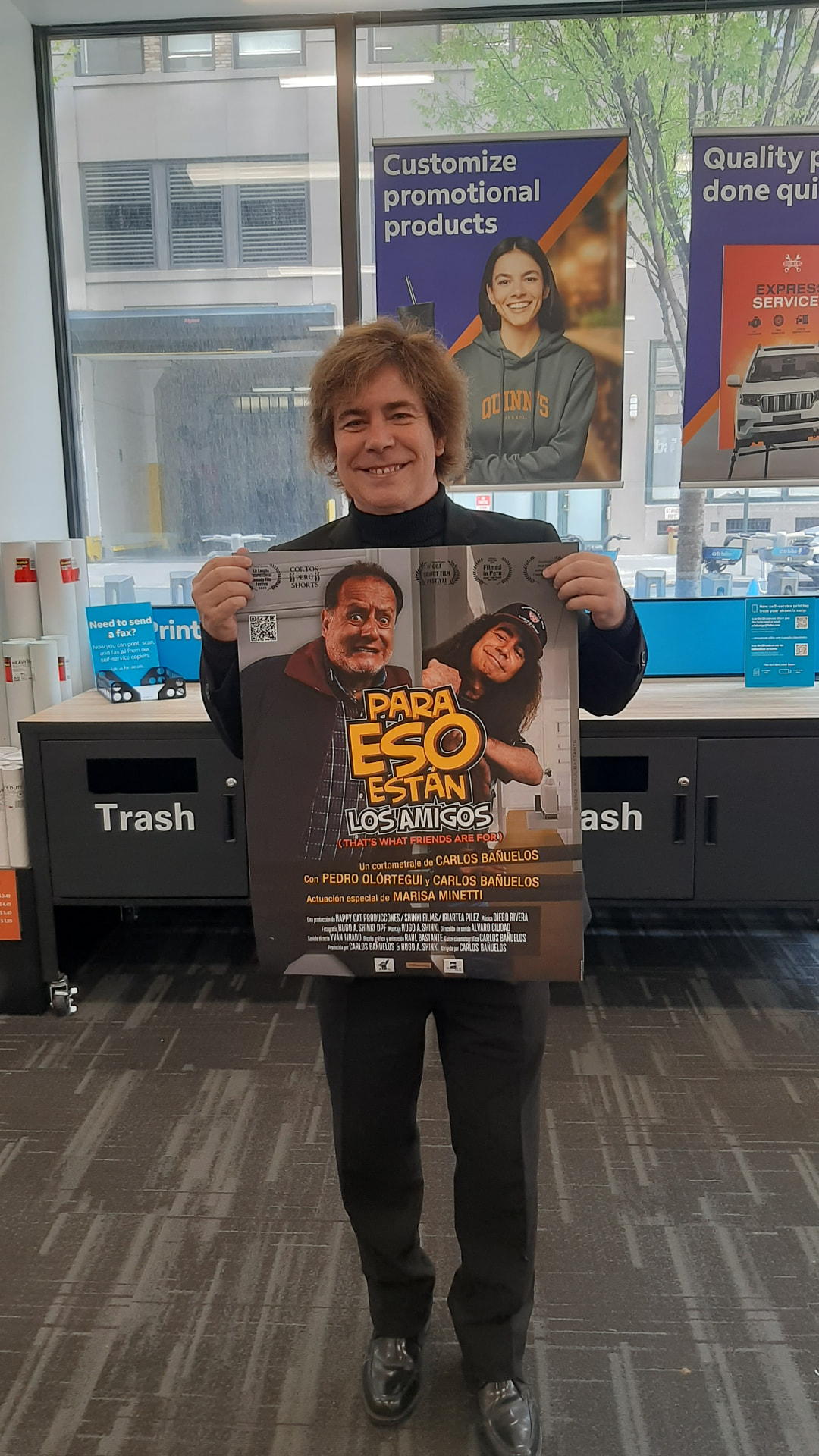 Carlos Bañuelos con el póster de «Para eso están los amigos» en Nueva York